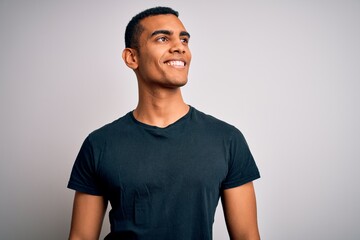 Young handsome african american man wearing casual t-shirt standing over white background looking...