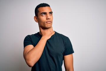 Young handsome african american man wearing casual t-shirt standing over white background Touching painful neck, sore throat for flu, clod and infection