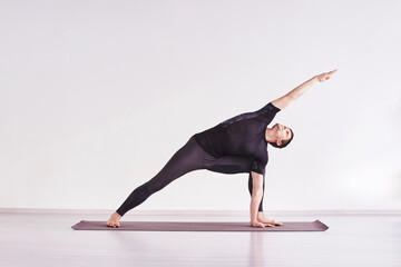 Man in yoga asana. Home lockdown studio. One person. Gym fitness. Morning meditating exercise. sport workout. Caucasian male relaxation. Balance energy mudra. Black. Horizontal. parsvakonasana