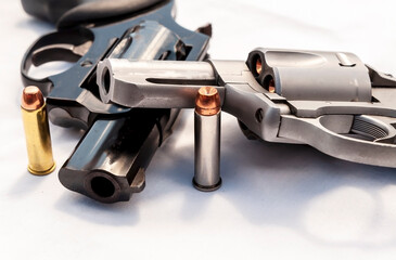 Two revolvers, a 357 magnum and a 38 special with hollow point bullets for each of them on a white background