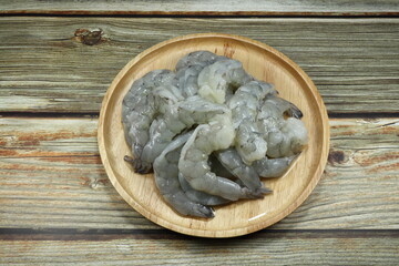 Fresh peeled shrimp on the wooden plate. Preparation raw material in the kitchen. Famous seafood ingredients in Asia. 