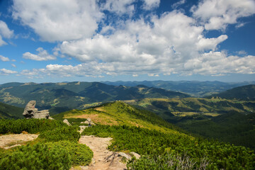Fototapeta na wymiar Landscape of mountainous rocky terrain with a trail on a background of blue sky