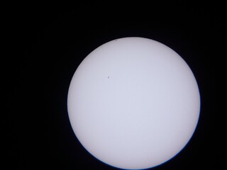 the sun and sunspots viewed through a solar filter on a telescope