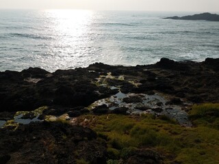 Fototapeta na wymiar sun shining on water at ocean shore