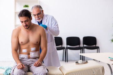 Injured young man visiting experienced male doctor