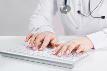 Fototapeta premium Close up doctor typing on computer keyboard