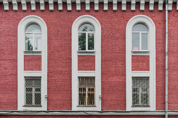Red brick facade of building. Two floors.