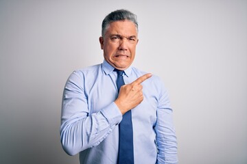 Middle age handsome grey-haired business man wearing elegant shirt and tie Pointing aside worried and nervous with forefinger, concerned and surprised expression