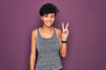 Young beautiful african american afro sportswoman doing exercise wearing sportswear showing and pointing up with fingers number two while smiling confident and happy.