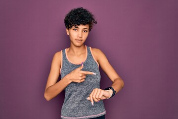 Young beautiful african american afro sportswoman doing exercise wearing sportswear In hurry...