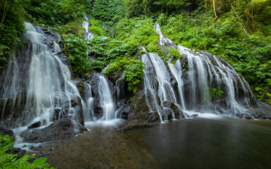 Waterfall landscape. Beautiful hidden waterfall in tropical rainforest. Nature background. Slow shutter speed, motion photography. Pucak Manik waterfall, Bali, Indonesia