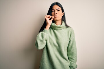 Young beautiful hispanic woman wearing green winter sweater over isolated background mouth and lips...