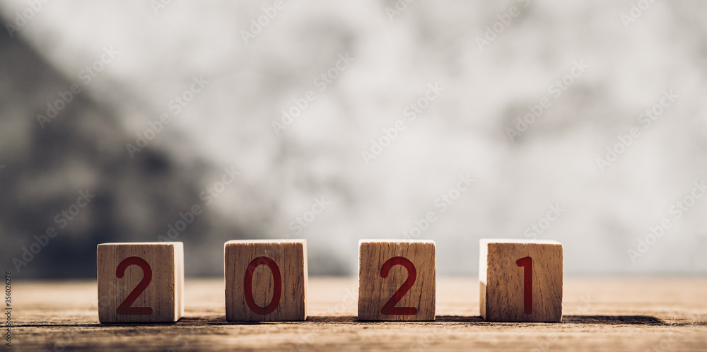 Aufkleber 2021 happy new year on wood block on wood table and concrete wall with sunlight from window.hope new