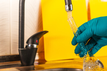 water purification specialist tap water pours into a glass flask.
