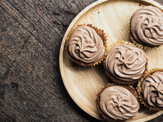 Cheesecake with chocolate whipped cream on wooden table