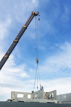 Construction site image show working of crane lift precast concrete wall for build new home.