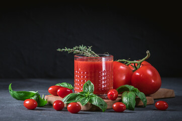 Glass of tomato juice with vegetables on wooden background