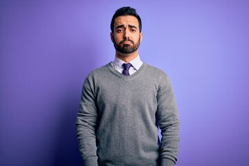 Handsome businessman with beard wearing casual tie standing over purple background depressed and worry for distress, crying angry and afraid. Sad expression.