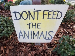 white and yellow don't feed the animals sign