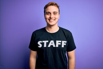 Young handsome redhead worker man wearing staff t-shirt uniform over purple background with a happy and cool smile on face. Lucky person.