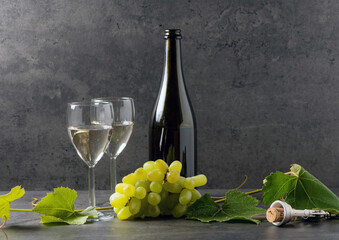 still life with white wine and grapes on a dark background