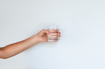 Female hand holds glass of water, isolated on white background