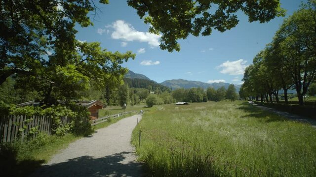 Tracking shot towards Schwarzsee Lake, with the beautiful Austrian Alps in the background on a clear sunny day