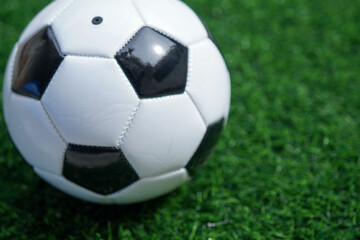 Traditional soccer ball or football on soccer football field. Copy space for text
