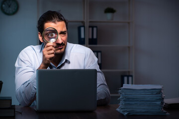 Young male employee working in the office night time