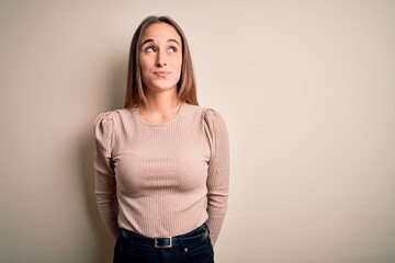 Obraz premium Young beautiful woman wearing casual sweater standing over isolated white background smiling looking to the side and staring away thinking.