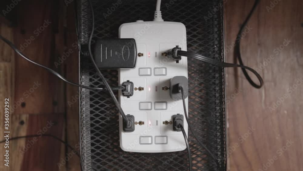 Poster switching on a power strip with many plugs. overhead view