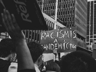 Protestors chanting passionately during the BLM protest in Sydney 2020. Large signs reads 'Racism...