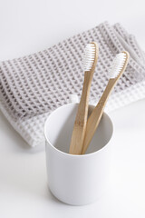 natural eco friendly toothbrush with wooden bamboo handle in a white cup