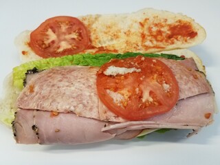 sandwich with tomato and bread and salami on white desk