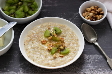 Oatmeal breakfast with butter, kiwi, hazelnuts and cinnamon.