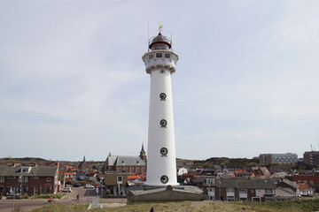Fototapeta na wymiar J.C.J. van Speijk Lighthouse (1833) is an old Dutch white lighthouse on the North Sea coast in the village Egmond aan Zee. 