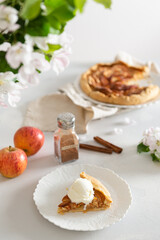 Piece of Baked galette or open pie with apples, cinnamon and ice cream on the table. Pastry, traditional french cuisine recipe. Bakery. Side view, cookbook, restaurant menu