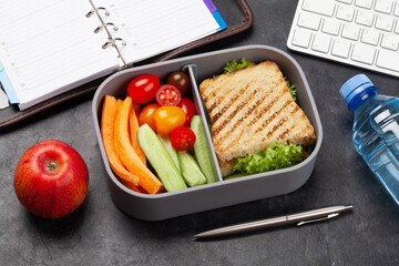 Healthy lunch box with sandwich and vegetables