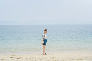 Fototapeta na wymiar 海辺を散策する女性