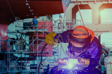 Man working and Welding close up ship repair at stern ship propeller with rudder background at...