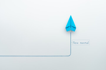 New normal concept with blue paper plane in new direction on white background