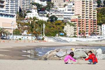 Two children playing on the beach in Atami, Shizuoka, Japan.
