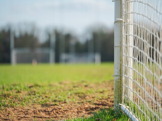 Side of goal post in focus, Two goal posts for Irish National sport camogie, hurling, rugby and football out of focus in the background. © mark_gusev
