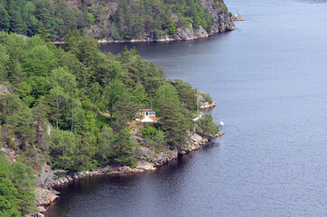 Obraz premium Typical Swedish nature and houses on the shore of the fjord. View from the high bridge over the fjord. The border of Norway and Sweden.Near the town Selater,Sweden