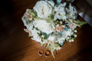 gold wedding rings near the bride's bouquet