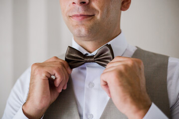 man puts on a bow-tie