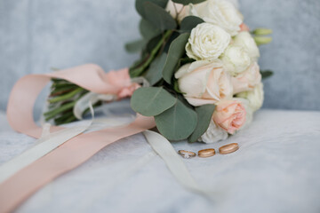 gold wedding rings near the bride's bouquet