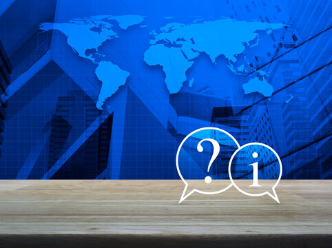 Question mark and information chat icon on wooden table over world map, modern city tower and skyscraper, Business customer service and support online concept, Elements of this image furnished by NASA