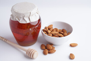 Almond, dates and honey on white background. This is a power and healthy food for diet and sunnah food.