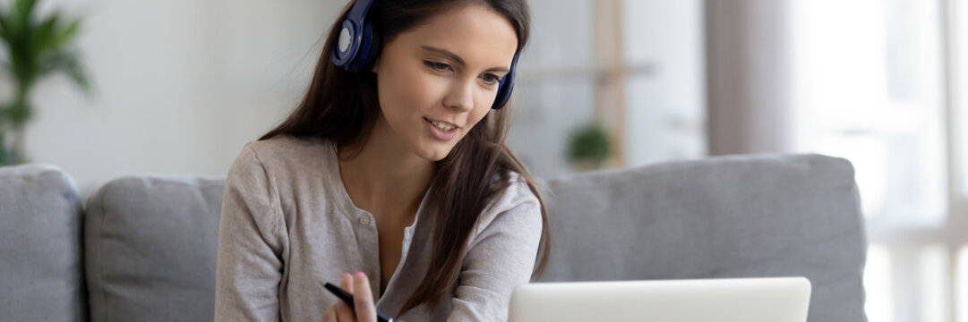 Woman wear headphones talk via video conference provide consultation help to client do remote job from home. E-study using modern tech concept, horizontal photo banner for website header design tech